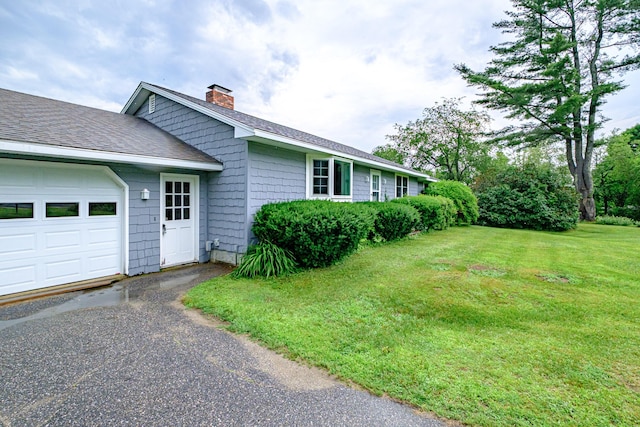 704 Brighton Hill Rd, Minot, ME 04258 - view of side of property featuring a chimney, a yard, roof with shingles, and an attached garage