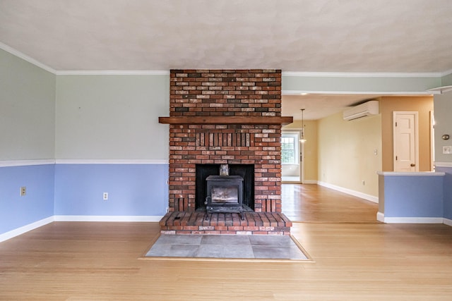 704 Brighton Hill Rd, Minot, ME 04258 - unfurnished living room with wood finished floors, a wall mounted air conditioner, a wood stove, and crown molding