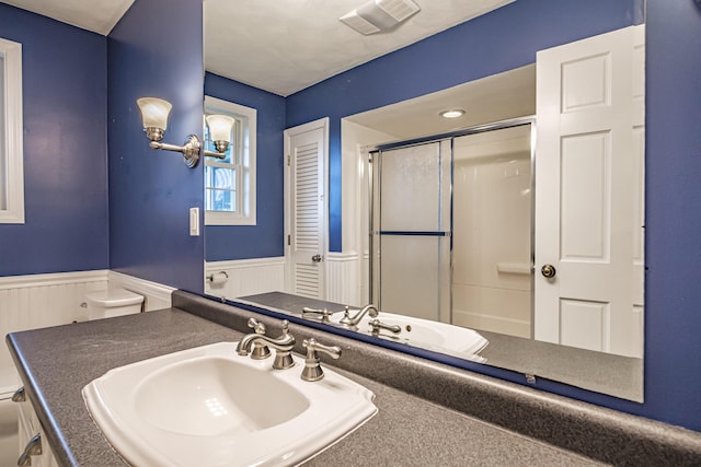 704 Brighton Hill Rd, Minot, ME 04258 - bathroom featuring a wainscoted wall, a shower with door, and vanity