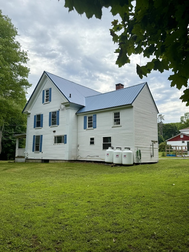 69 Lafayette St, Calais, ME 04619 - back of house with a lawn, a metal roof, and a chimney
