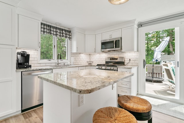 68 Appletree Ln, Wells, ME 04090 - kitchen featuring appliances with stainless steel finishes, decorative backsplash, white cabinetry, and healthy amount of natural light