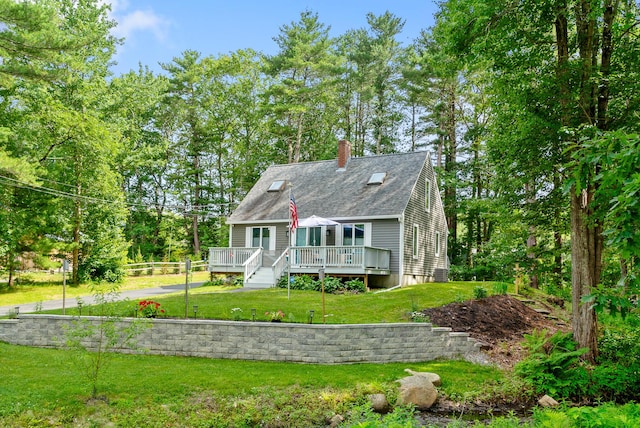 68 Appletree Ln, Wells, ME 04090 - new england style home with a chimney, a front yard, a wooden deck, and roof with shingles