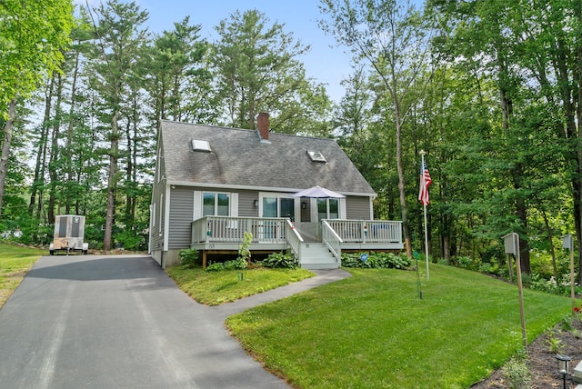 68 Appletree Ln, Wells, ME 04090 - view of front of property featuring a chimney, a front lawn, a wooden deck, a shingled roof, and view of scattered trees