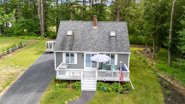 68 Appletree Ln, Wells, ME 04090 - view of front of house with roof with shingles, a chimney, a front yard, a wooden deck, and view of scattered trees