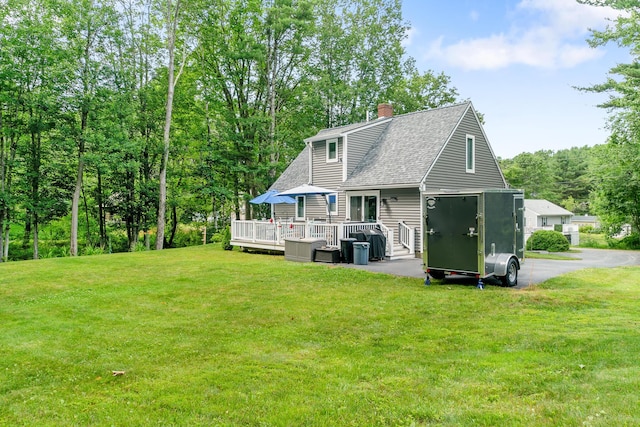 68 Appletree Ln, Wells, ME 04090 - back of property featuring a shingled roof, a deck, a yard, and a chimney