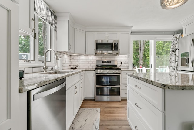 68 Appletree Ln, Wells, ME 04090 - kitchen with stainless steel appliances, tasteful backsplash, white cabinetry, light wood-type flooring, and light stone countertops