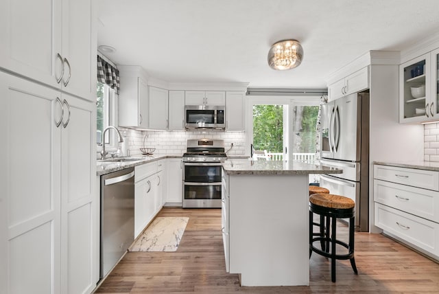 68 Appletree Ln, Wells, ME 04090 - kitchen featuring appliances with stainless steel finishes, tasteful backsplash, a breakfast bar, and light stone countertops