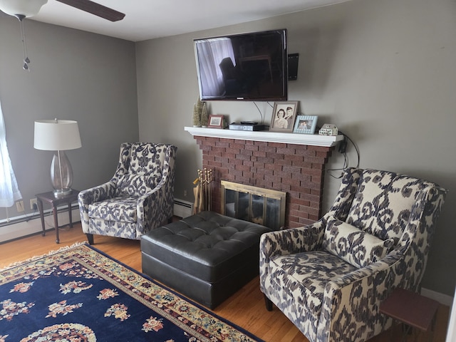 125 Connecticut Ave, Millinocket, ME 04462 - sitting room featuring wood finished floors, a fireplace, a ceiling fan, and a baseboard radiator