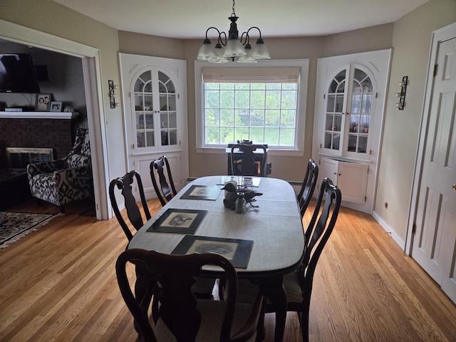 125 Connecticut Ave, Millinocket, ME 04462 - dining space with a chandelier, light wood-style flooring, and a fireplace