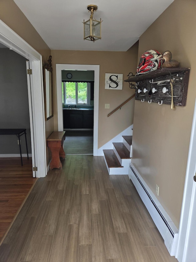 125 Connecticut Ave, Millinocket, ME 04462 - entrance foyer featuring a baseboard heating unit, stairway, and wood finished floors