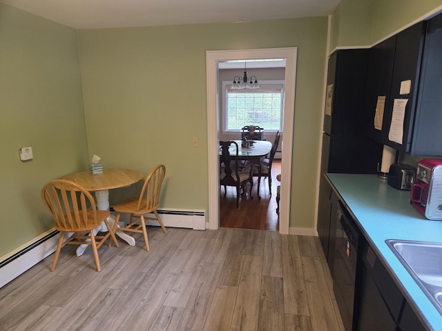 125 Connecticut Ave, Millinocket, ME 04462 - dining space featuring light wood-style flooring, a chandelier, and a baseboard heating unit