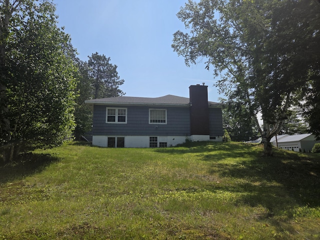 125 Connecticut Ave, Millinocket, ME 04462 - back of house with a chimney and a lawn