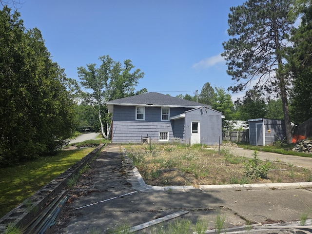 125 Connecticut Ave, Millinocket, ME 04462 - rear view of property with a storage shed and roof with shingles
