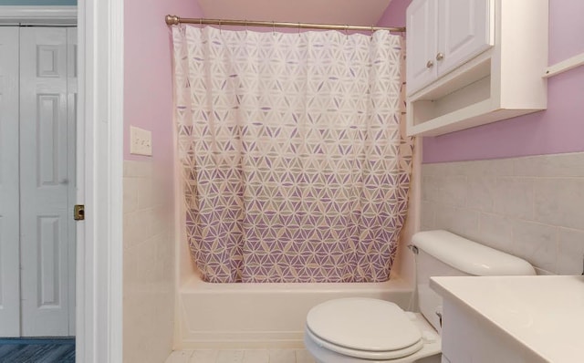 504 Balch Mill Rd, Newfield, ME 04095 - bathroom featuring shower / bathtub combination with curtain, tile walls, vanity, and a wainscoted wall