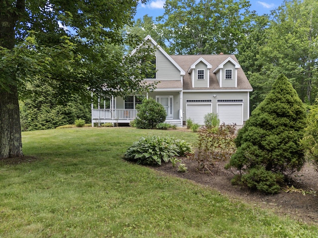 17 Tuttle Ln, Wells, ME 04090 - view of front of home with a front yard, a garage, a shingled roof, and covered porch