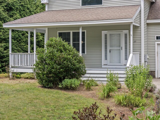 17 Tuttle Ln, Wells, ME 04090 - view of property exterior featuring a shingled roof, a porch, and a lawn