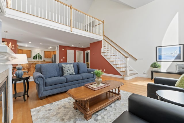 17 Tuttle Ln, Wells, ME 04090 - living room featuring a high ceiling, stairs, light wood-style flooring, recessed lighting, and a glass covered fireplace