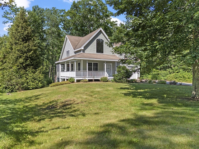 17 Tuttle Ln, Wells, ME 04090 - farmhouse inspired home with a porch, a front lawn, and a shingled roof