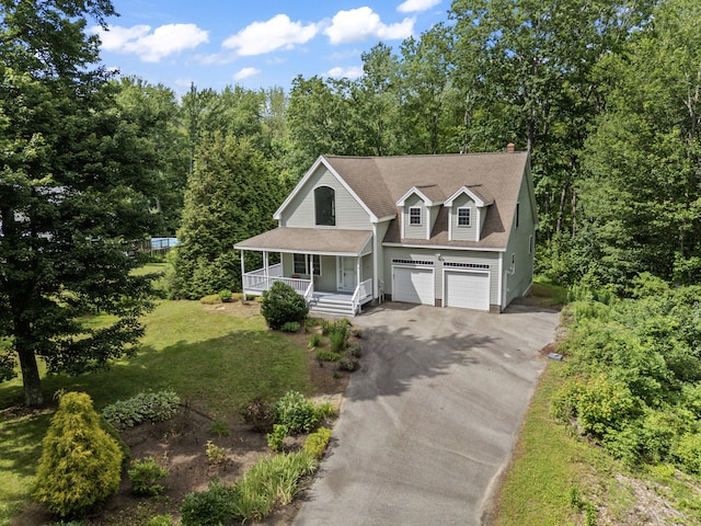 17 Tuttle Ln, Wells, ME 04090 - view of front of property with a porch, asphalt driveway, a garage, and a shingled roof