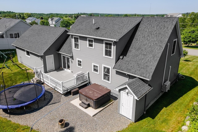 123 Lasalle Dr, Bangor, ME 04401 - rear view of house featuring a trampoline, roof with shingles, a hot tub, and a wooden deck