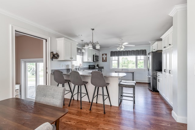 123 Lasalle Dr, Bangor, ME 04401 - kitchen featuring appliances with stainless steel finishes, a peninsula, dark wood-style floors, white cabinets, and a kitchen breakfast bar
