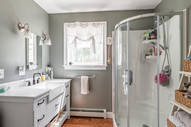 123 Lasalle Dr, Bangor, ME 04401 - bathroom featuring a baseboard heating unit, vanity, a shower stall, and wood finished floors
