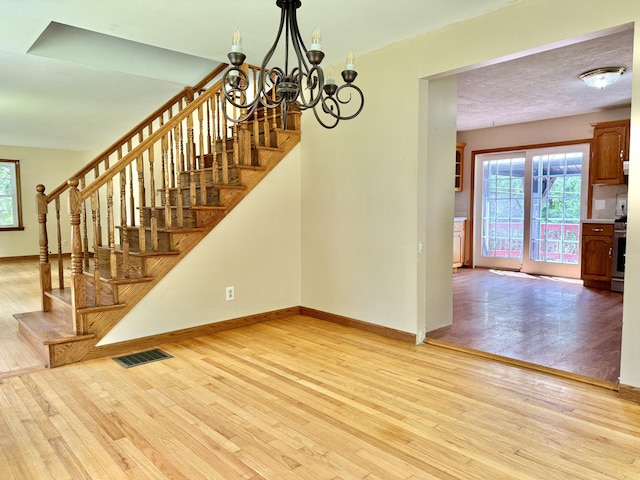 1606 Avenue Rd, Exeter, ME 04435 - staircase featuring a chandelier and wood finished floors