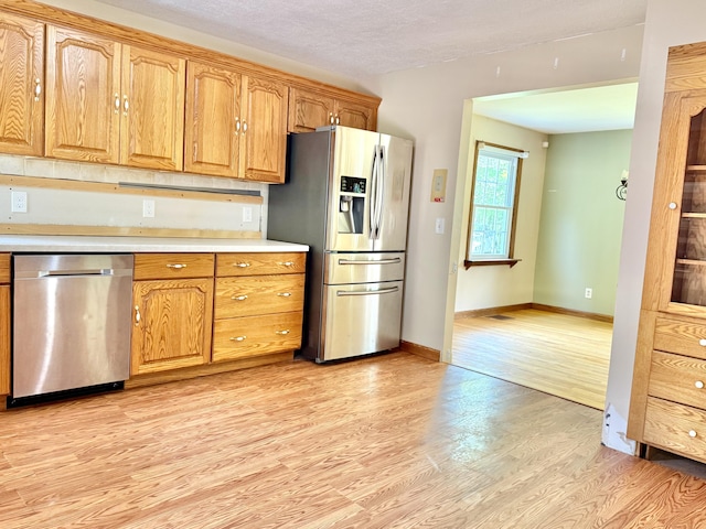 1606 Avenue Rd, Exeter, ME 04435 - kitchen with stainless steel appliances, light wood finished floors, light countertops, and brown cabinetry