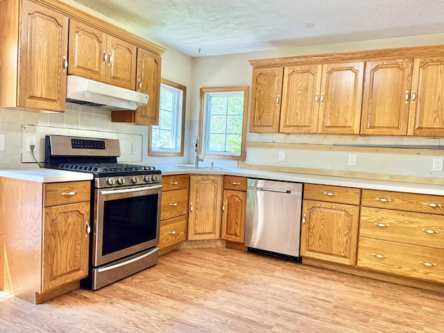 1606 Avenue Rd, Exeter, ME 04435 - kitchen featuring appliances with stainless steel finishes, under cabinet range hood, a textured ceiling, light wood-style flooring, and light countertops