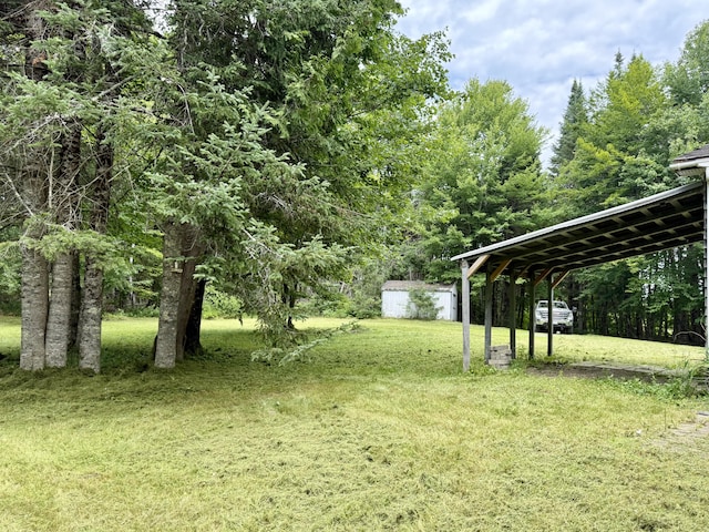 1606 Avenue Rd, Exeter, ME 04435 - view of green lawn featuring a detached carport and an outbuilding
