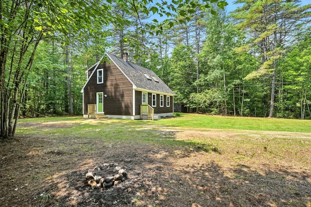 117 Badger Cir, Limerick, ME 04048 - view of side of home featuring entry steps, a chimney, roof with shingles, a lawn, and a forest view