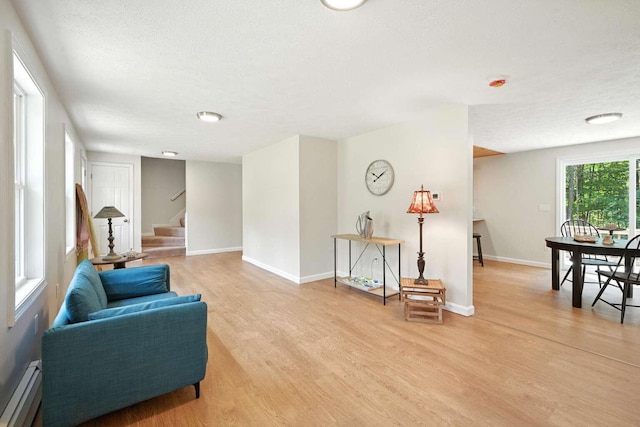 117 Badger Cir, Limerick, ME 04048 - sitting room featuring baseboard heating, light wood finished floors, stairs, and a textured ceiling