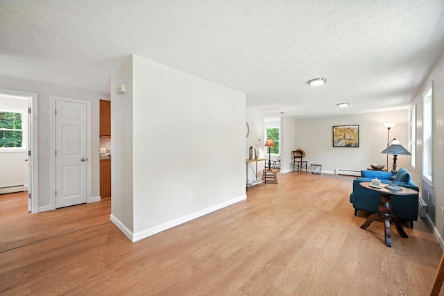 117 Badger Cir, Limerick, ME 04048 - living area with light wood-style flooring, a textured ceiling, and baseboard heating
