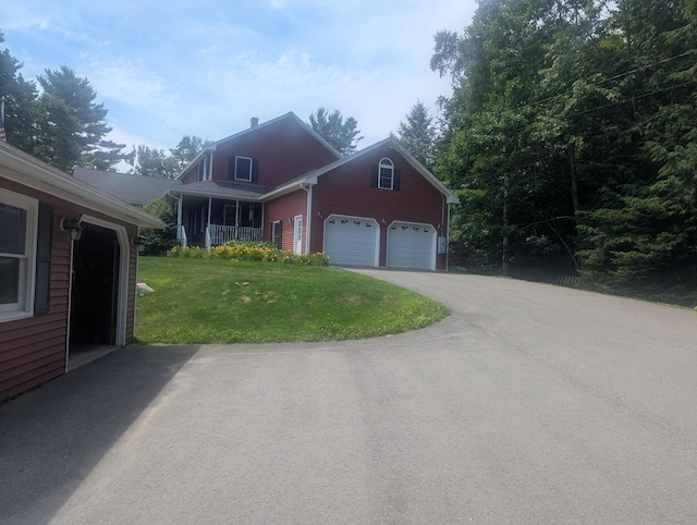 9 Deer Hill Ln, Hampden, ME 04444 - view of front of house featuring a front lawn, a garage, asphalt driveway, and a chimney