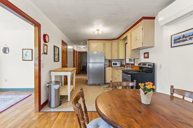490 Cross Point Rd, Edgecomb, ME 04556 - dining room with a wall mounted air conditioner and light wood-style flooring
