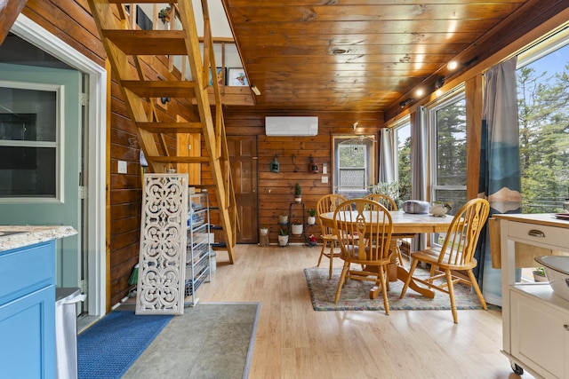 490 Cross Point Rd, Edgecomb, ME 04556 - dining area featuring wooden ceiling, wooden walls, light wood finished floors, stairway, and a wall unit AC
