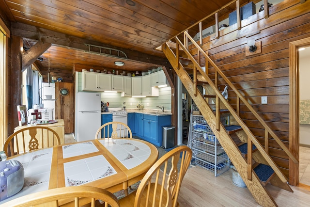 490 Cross Point Rd, Edgecomb, ME 04556 - dining room with light wood finished floors, wooden ceiling, stairs, and wooden walls