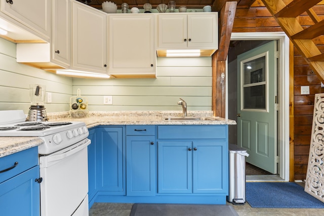 490 Cross Point Rd, Edgecomb, ME 04556 - kitchen featuring white electric range, blue cabinetry, wooden walls, and light stone counters