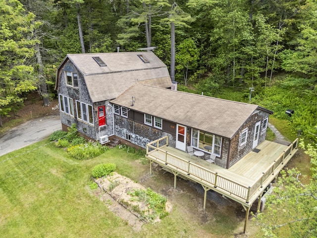 490 Cross Point Rd, Edgecomb, ME 04556 - view of front of home with a shingled roof, a deck, a front lawn, and a forest view