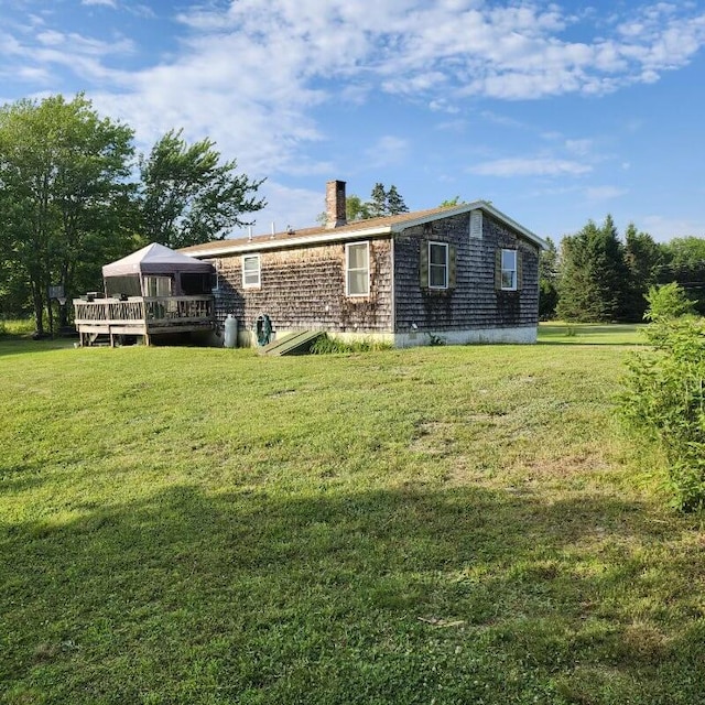 96 N Main St, Milbridge, ME 04658 - back of property with a wooden deck, a chimney, and a lawn