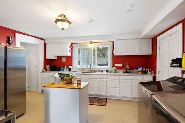 20 Winter St, Augusta, ME 04330 - kitchen with freestanding refrigerator, white cabinetry, light countertops, range, and a center island