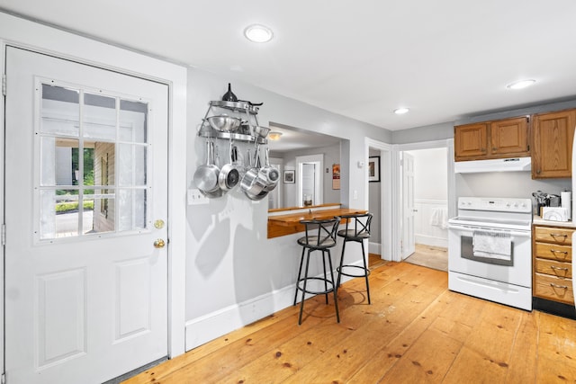 68 Newbury St, Auburn, ME 04210 - kitchen with white range with electric cooktop, under cabinet range hood, light wood-style floors, recessed lighting, and light countertops