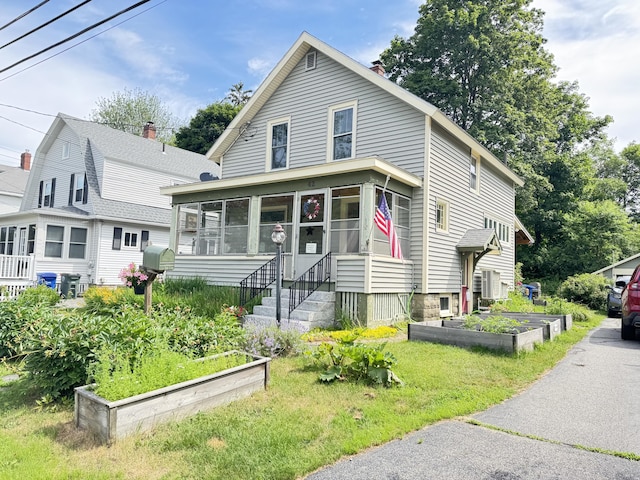 42 Sargent St, Westbrook, ME 04092 - view of front of home with a garden, a sunroom, a chimney, and a front lawn