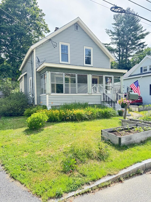 42 Sargent St, Westbrook, ME 04092 - view of front of home with a garden, a sunroom, and a front lawn
