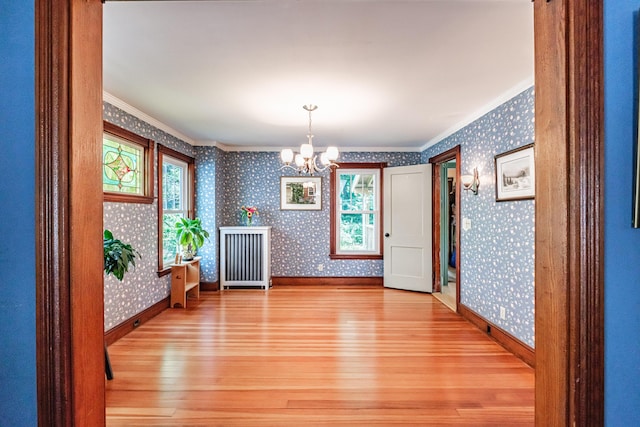 42 Sargent St, Westbrook, ME 04092 - unfurnished dining area featuring hardwood / wood-style floors, ornamental molding, wallpapered walls, and a chandelier