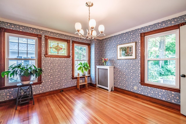 42 Sargent St, Westbrook, ME 04092 - unfurnished room featuring light wood-style flooring, plenty of natural light, a chandelier, wallpapered walls, and crown molding