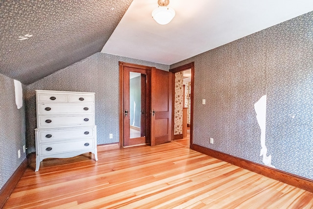 42 Sargent St, Westbrook, ME 04092 - additional living space featuring light wood-style floors, vaulted ceiling, and wallpapered walls