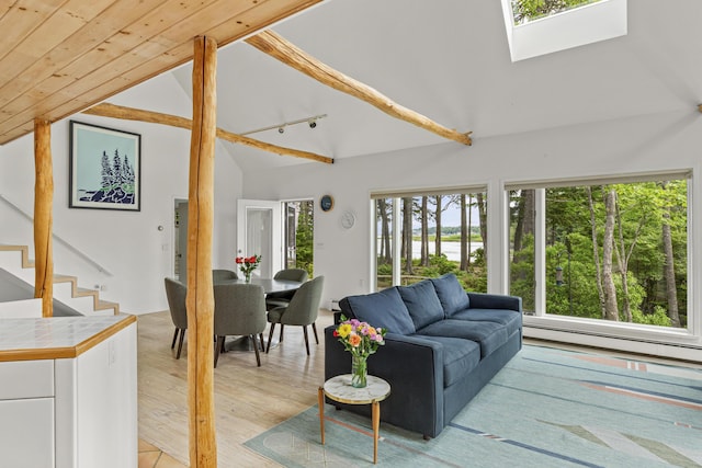 133 Scraggle Point Rd, Saint George, ME 04859 - living room featuring plenty of natural light, a skylight, a baseboard heating unit, stairway, and high vaulted ceiling