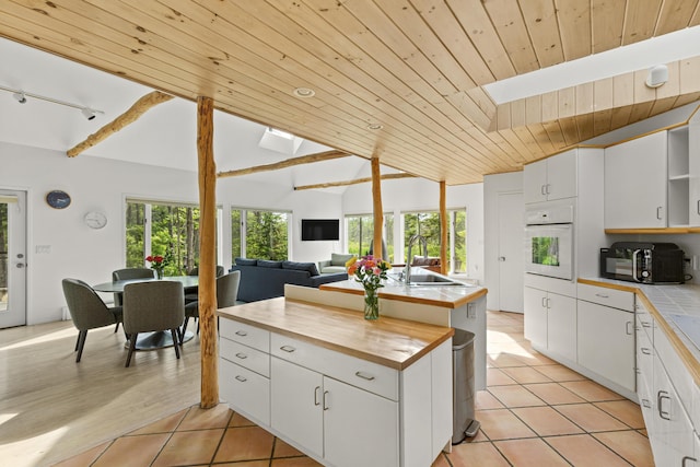 133 Scraggle Point Rd, Saint George, ME 04859 - kitchen featuring oven, black microwave, wooden ceiling, open shelves, and butcher block counters