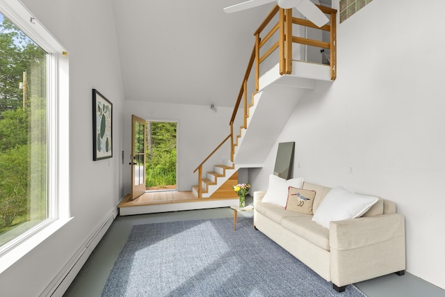 133 Scraggle Point Rd, Saint George, ME 04859 - living area featuring baseboard heating, stairway, ceiling fan, and lofted ceiling